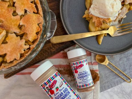 Apple pie with lattice crust topped with a scoop of Ice cream and cinnamon, alongside Bolner’s Fiesta Brand Sugar and Cinnamon